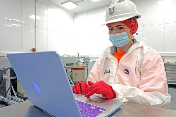 A Mitie colleague working on a laptop in a laboratory setting